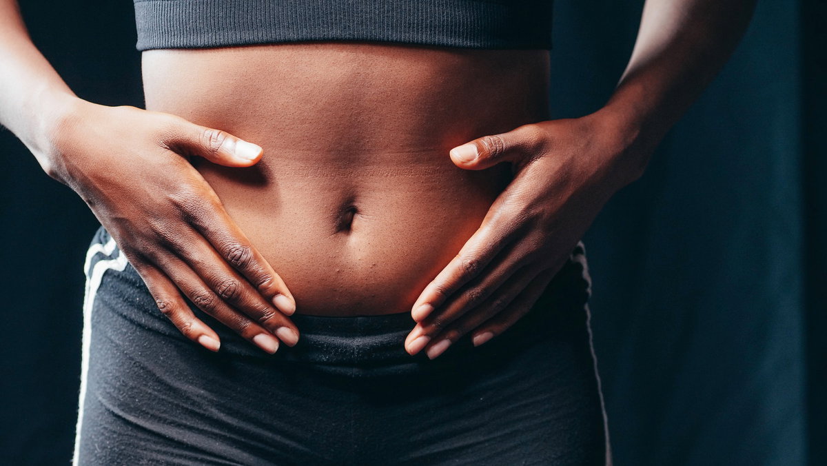 Frau legt Hände auf Ihren Bauch