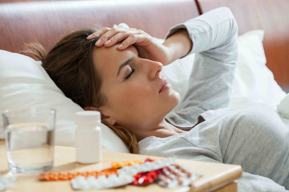 Frau liegt krank im Bett