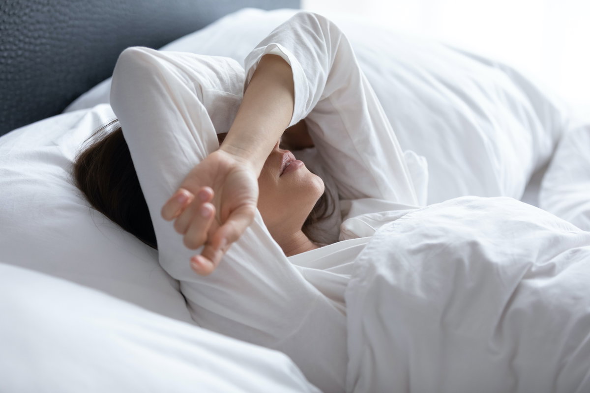 Kranke Frau liegt im Bett