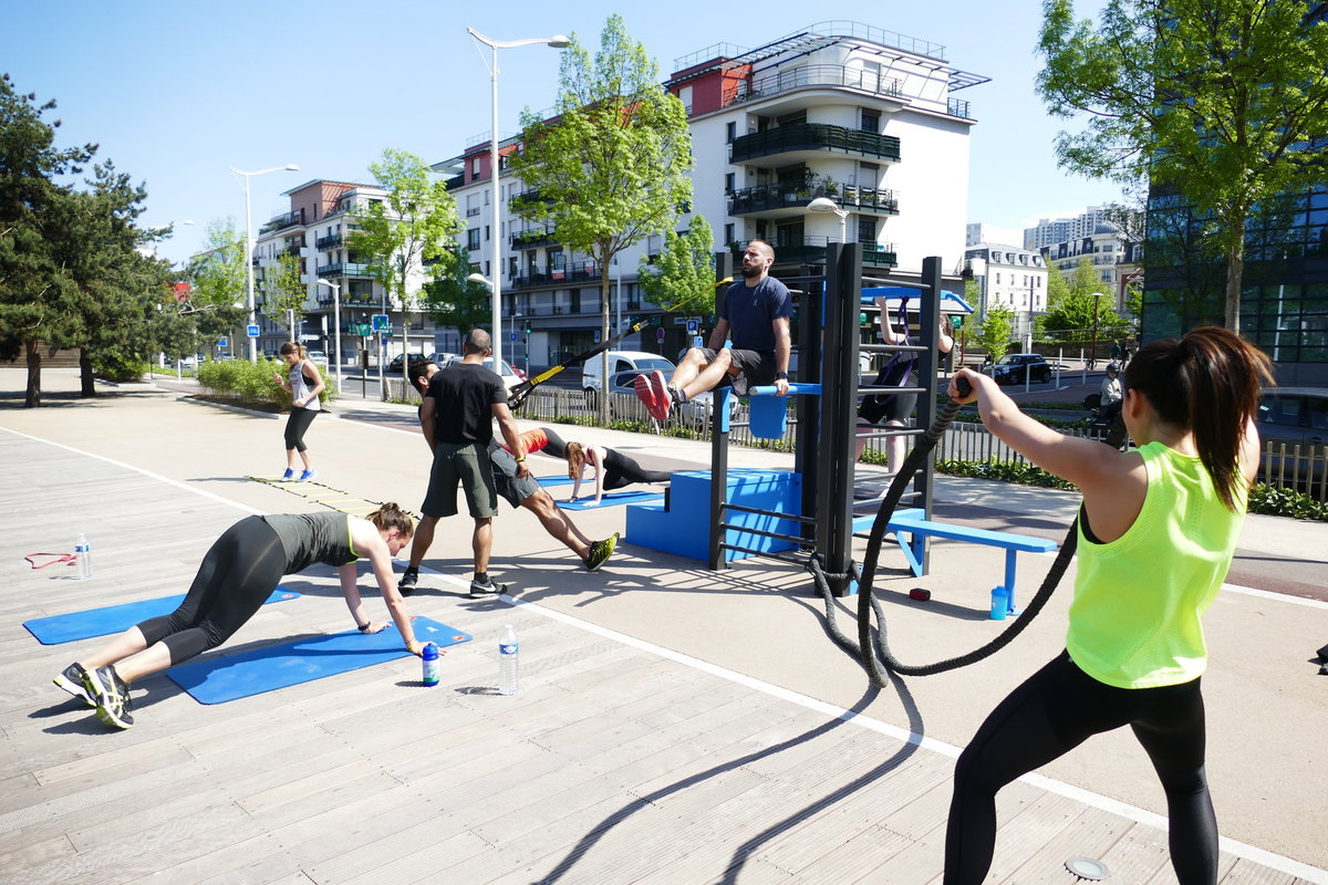 Menschen trainieren draußen mit Fitnessgeräten