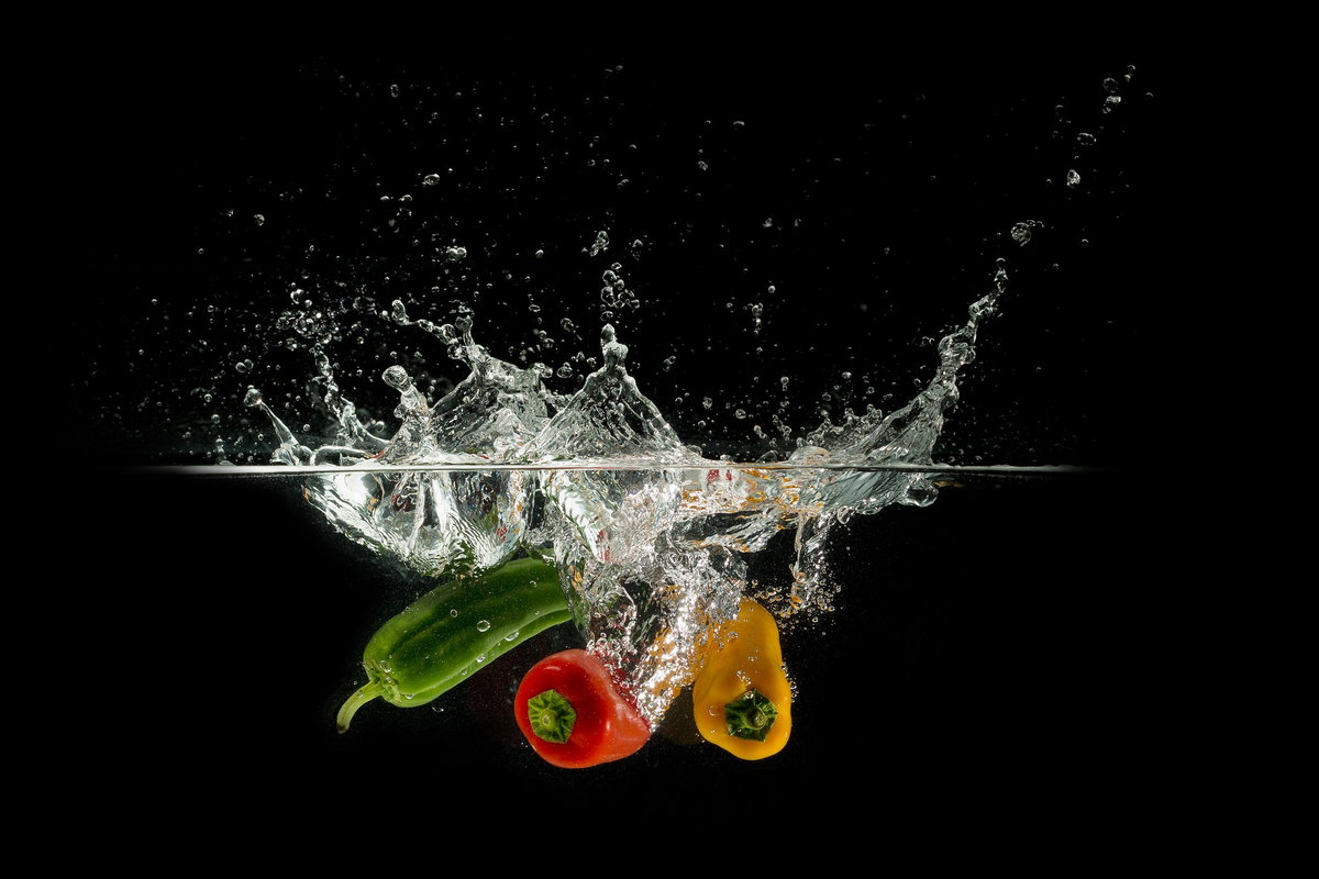 Drei Paprikaschoten fallen ins Wasser