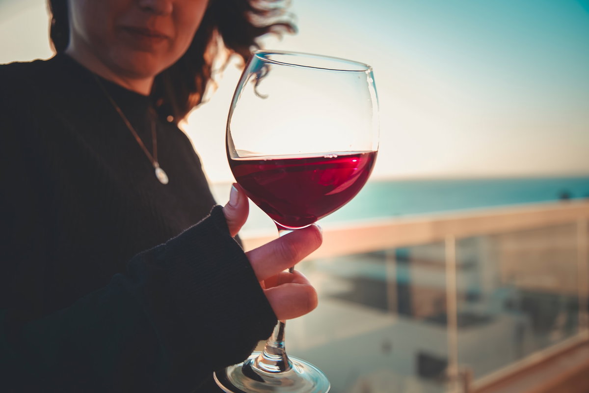 Frau hält ein Glas Rotwein in der Hand