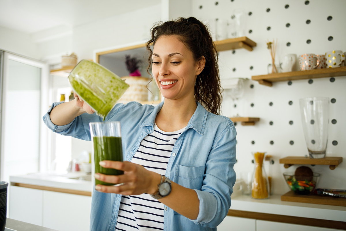 Frau bereitet Smoothie zu