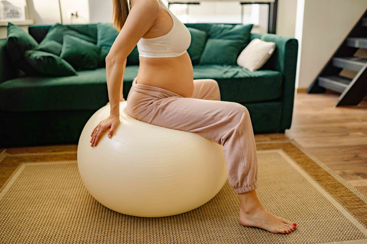 Schwangere Frau auf Gymnastikball
