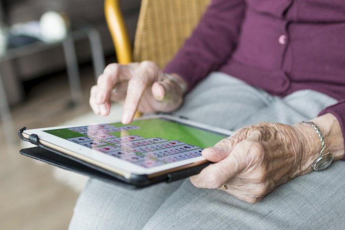 Ältere Frau tippt auf Tablet