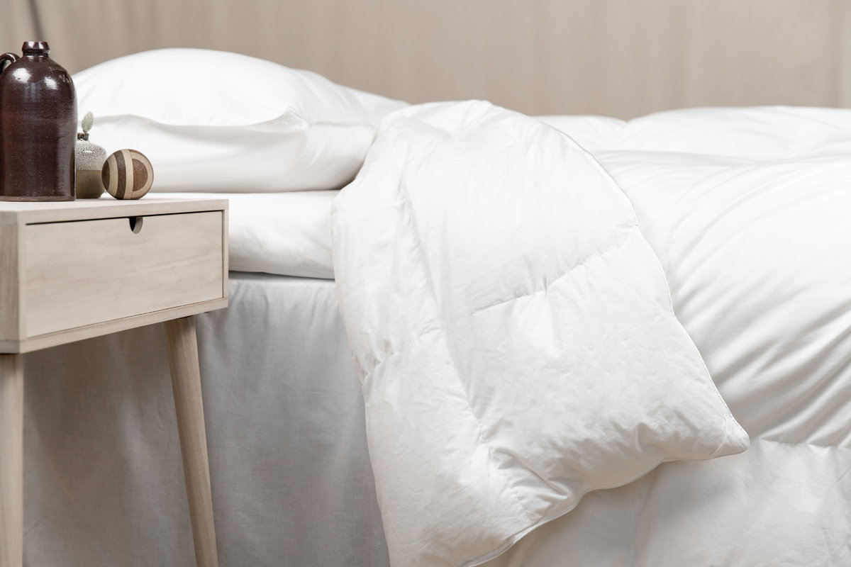 Ein Bett mit Gewichtsdecke und ein Nachttisch