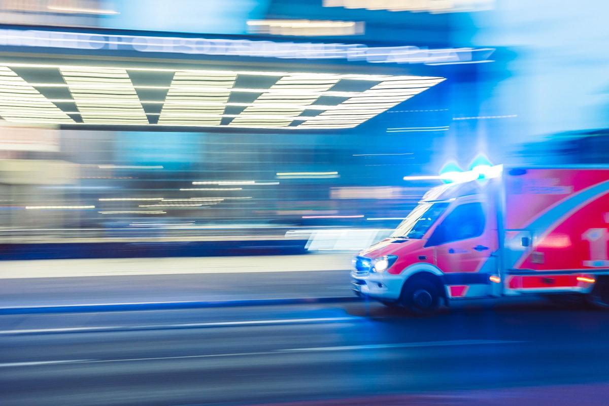 Krankenwagen mit Blaulicht rast auf Straße