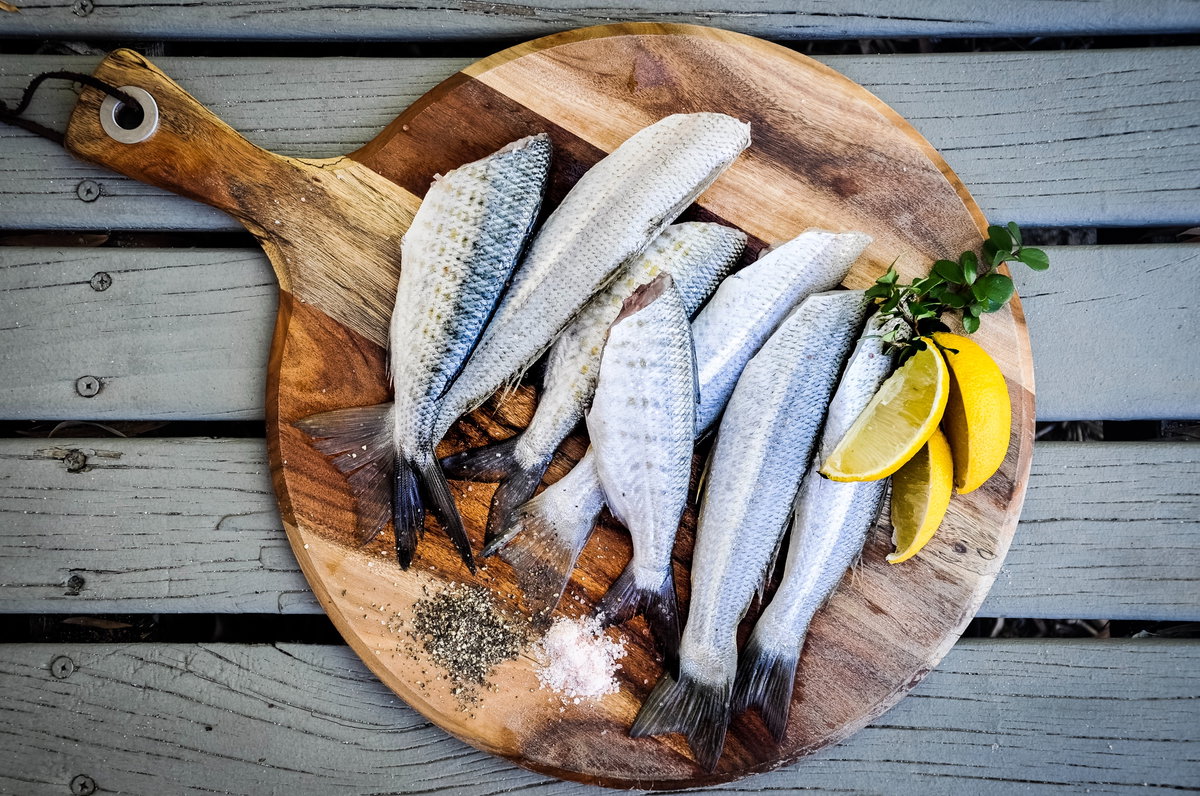 Frischer Fisch auf Holztablett angerichtet