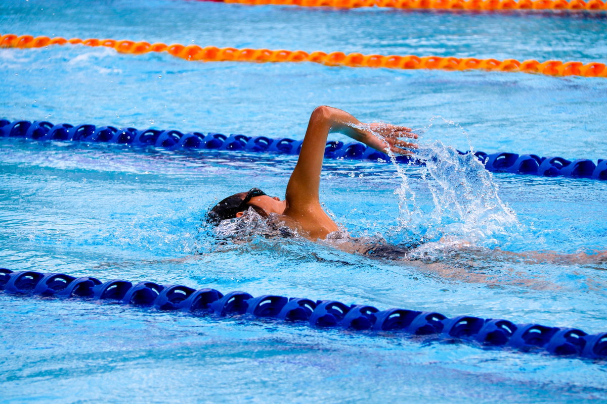 Person schwimmt im Schwimmbad