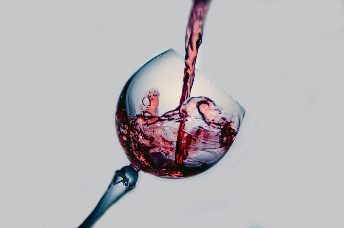 Weinglas wird mit Rotwein befüllt