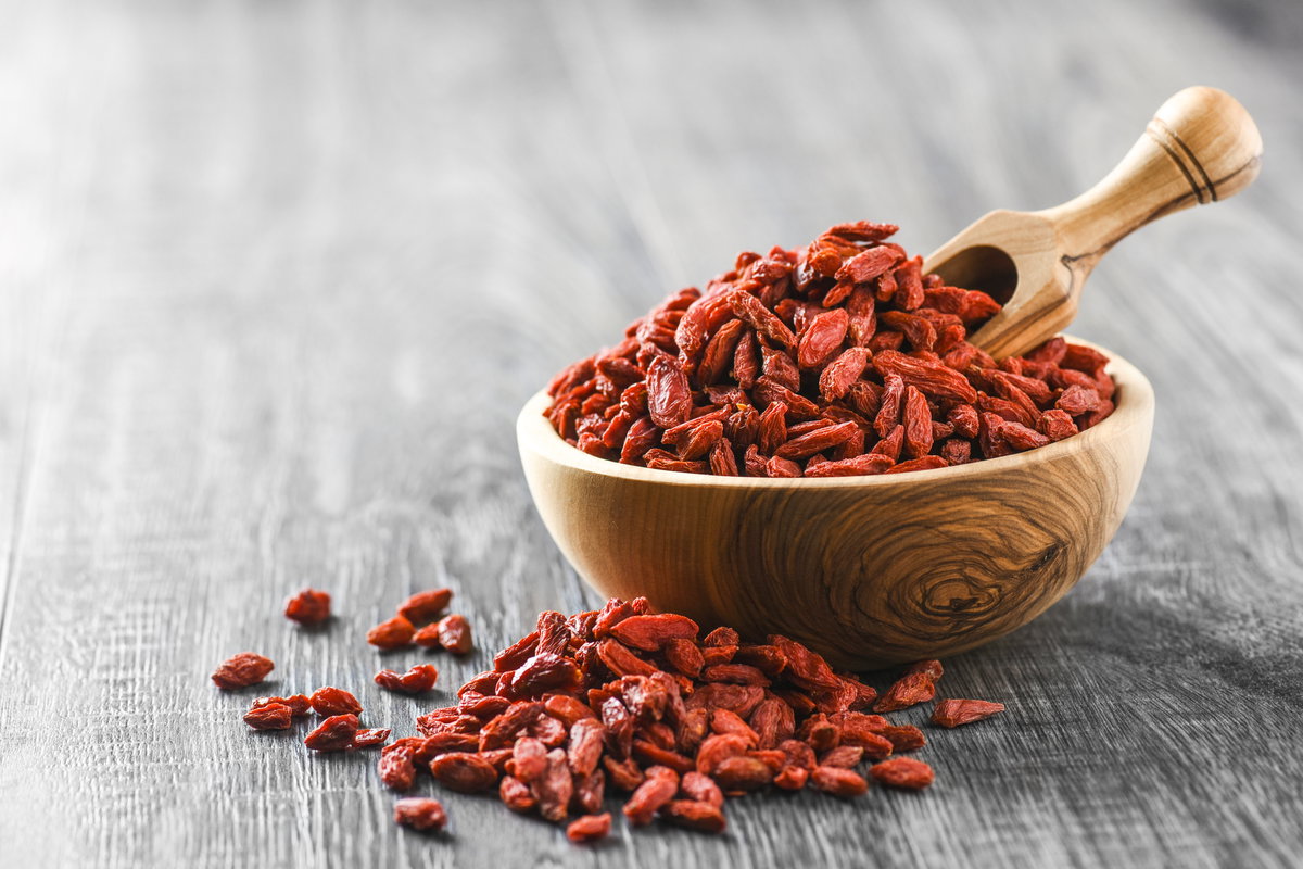 Goji-Beeren in Holzschale auf rustikalem Tisch