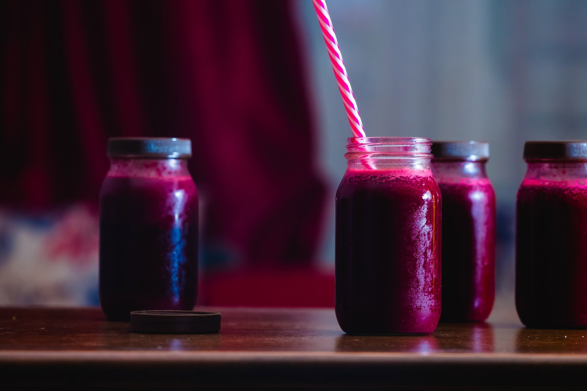 Rote-Beete-Saft in Einmachgläsern mit Strohhalm