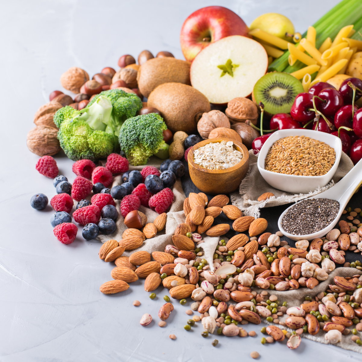Verschiedene pflanzliche Lebensmittel wie Obst, Gemüse, Nüsse und Samen