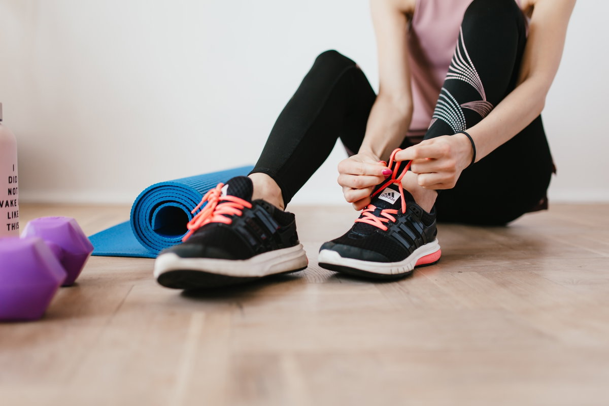 Frau bindet Sportschuhe zu
