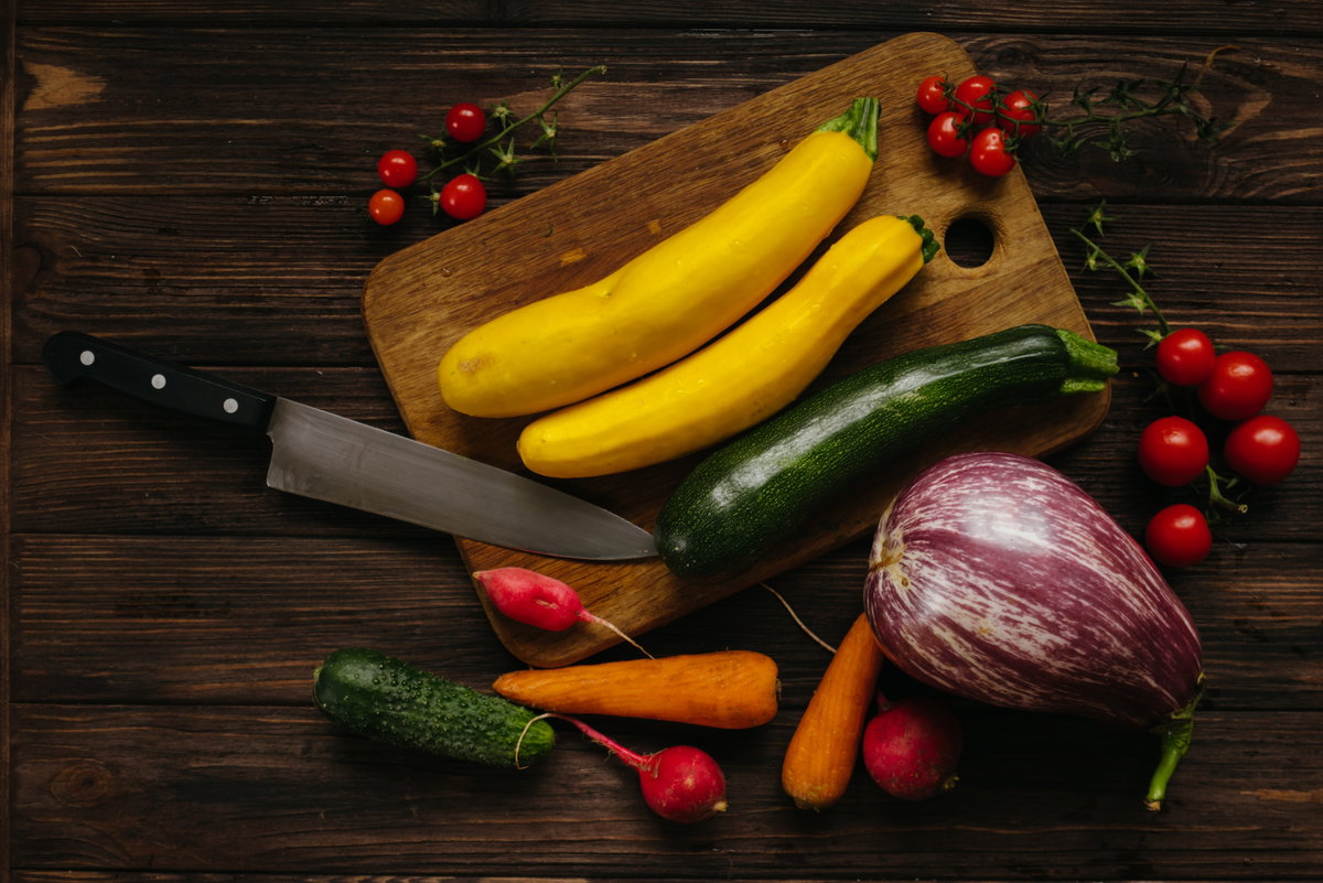Gelbe Zucchini auf Schneidebrett mit anderen Gemüsesorten