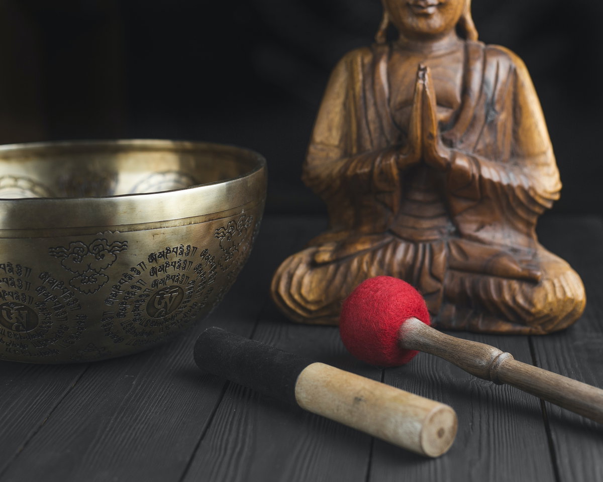 Klangschale mit Schlägel und Buddha-Statue