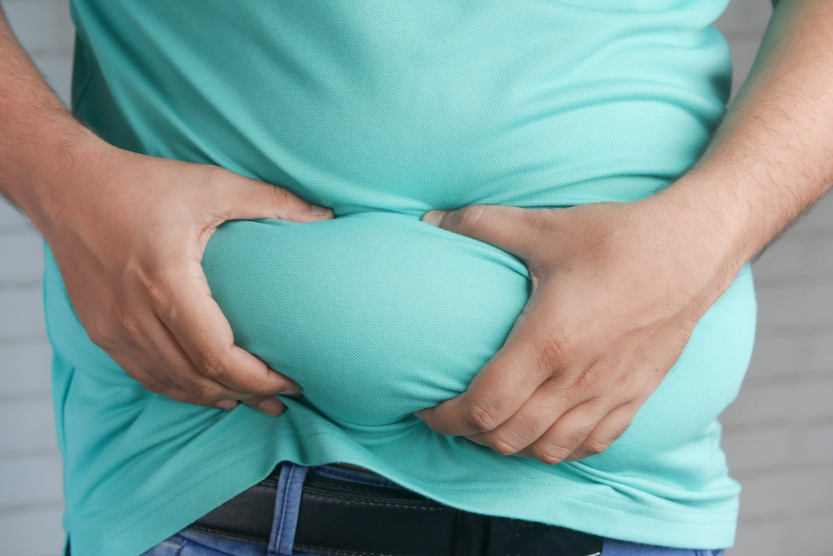 Mann greift sich an den dicken Bauch