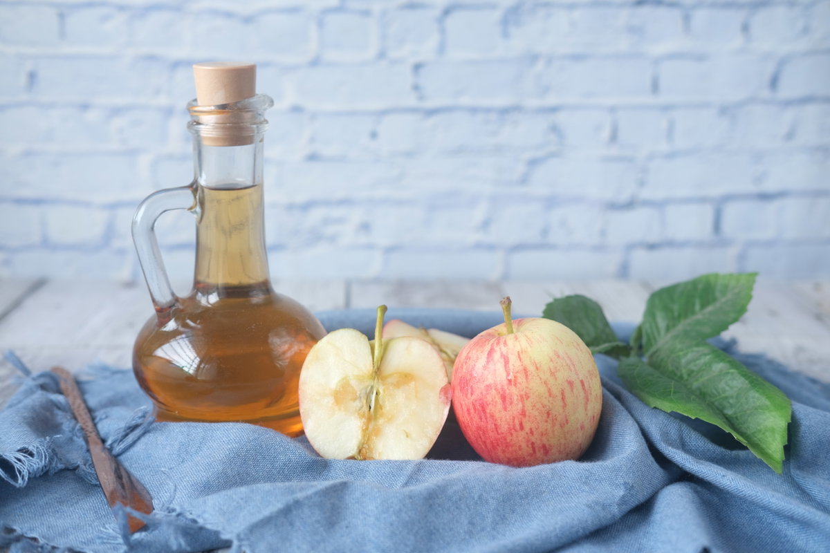 Apfelesig und aufgeschnittene Äpfel