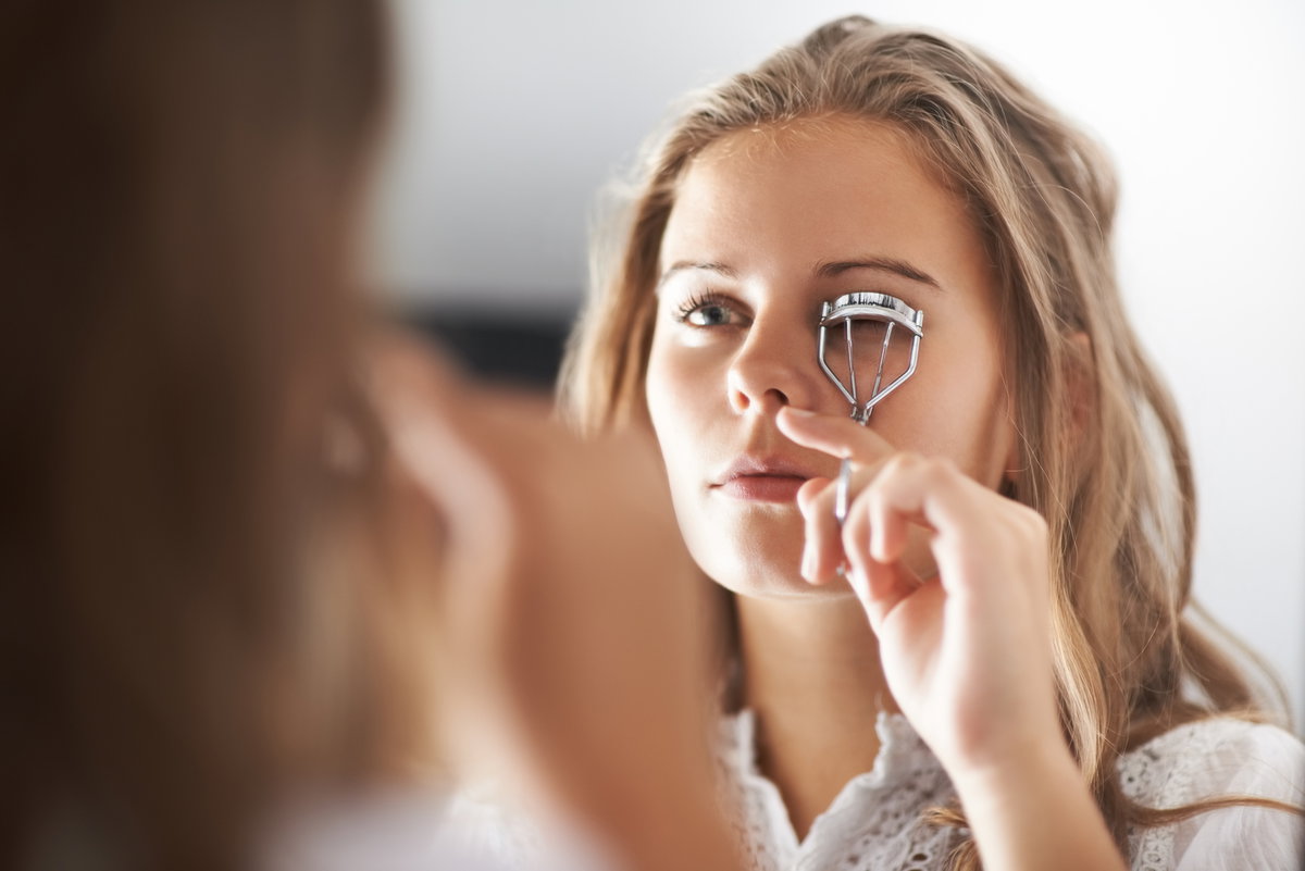 Frau benutzt Wimpernzange