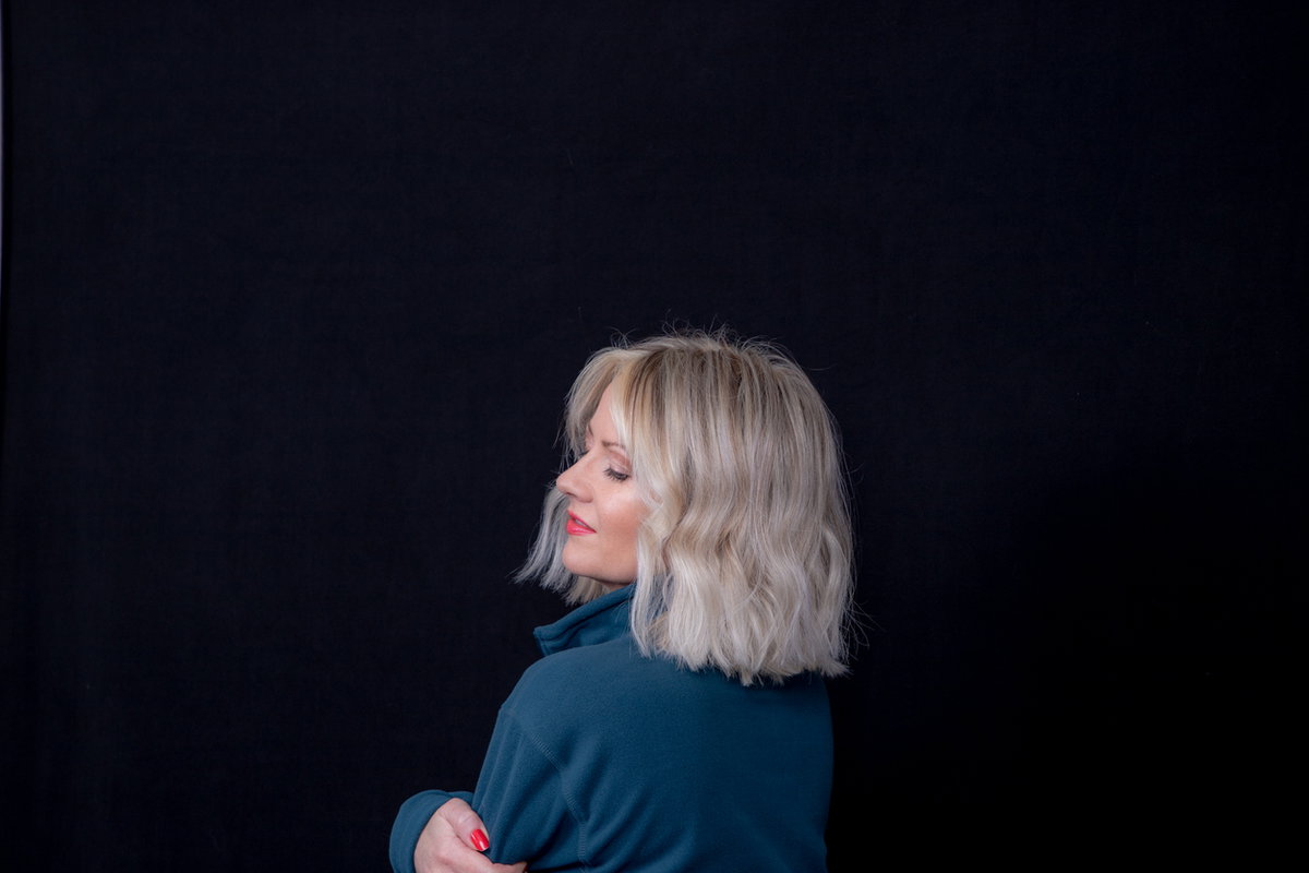 Frau mit Longbob vor schwarzem Hintergrund