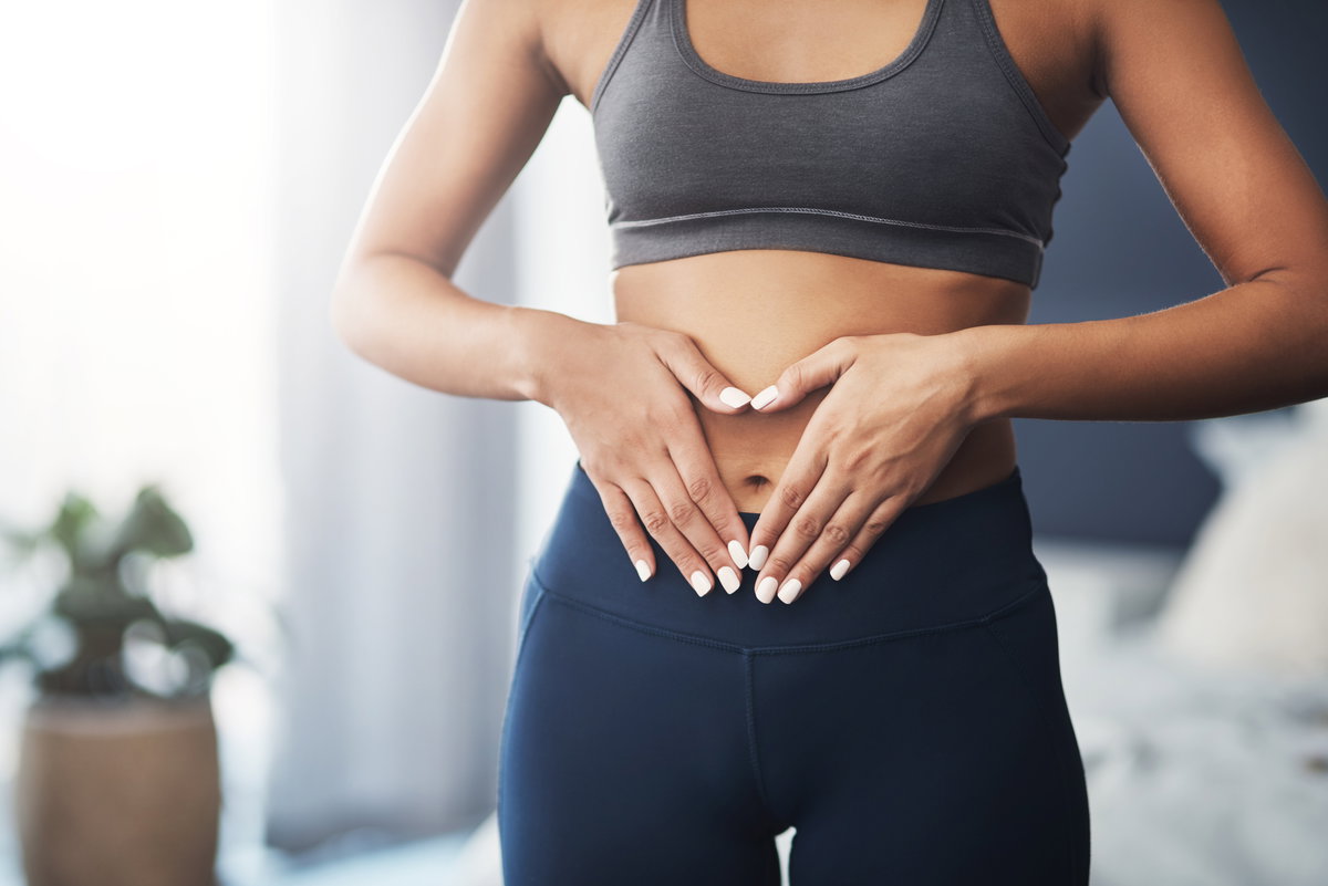 Frau legt Hände auf Bauch