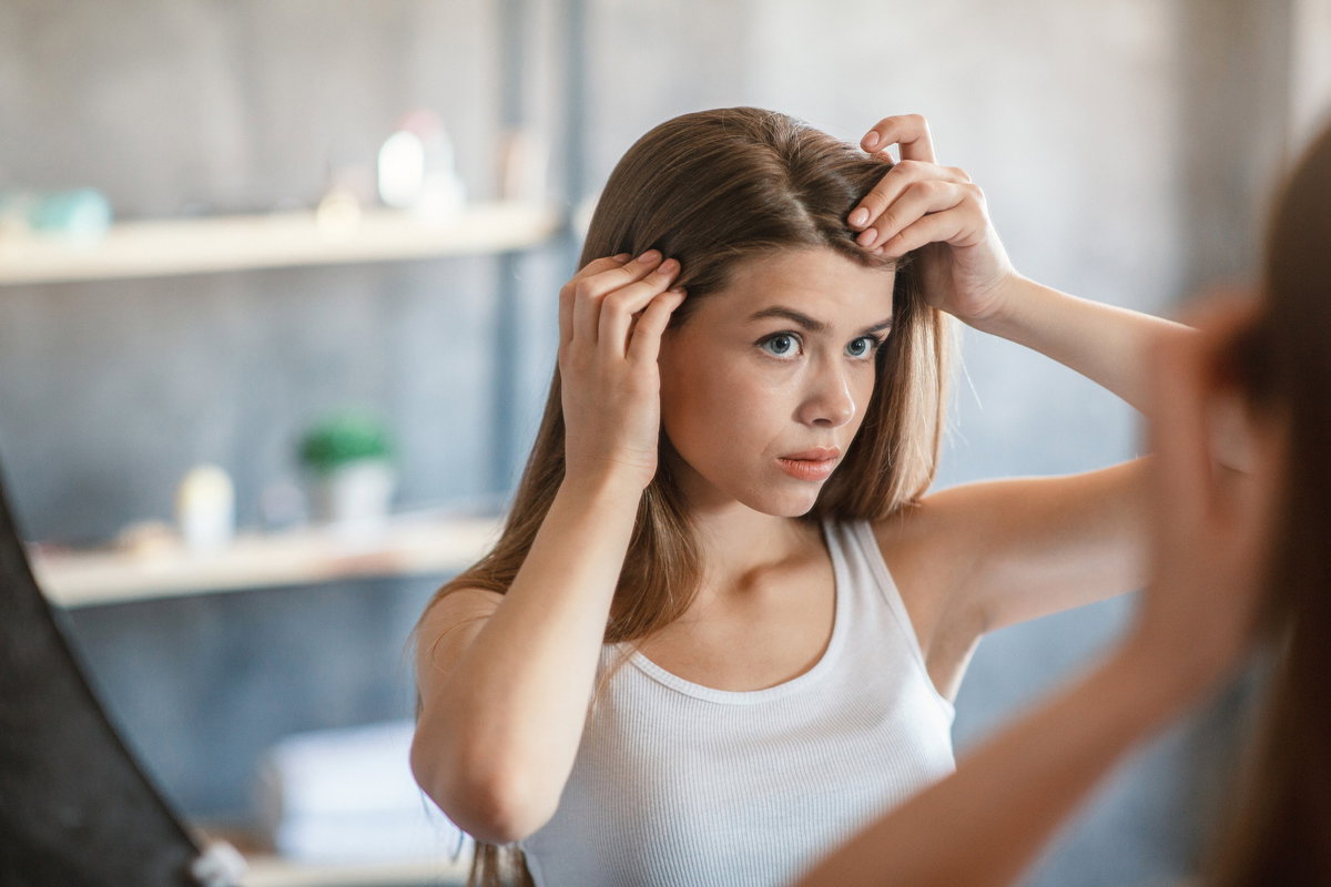 Frau begutachtet ihre Haare