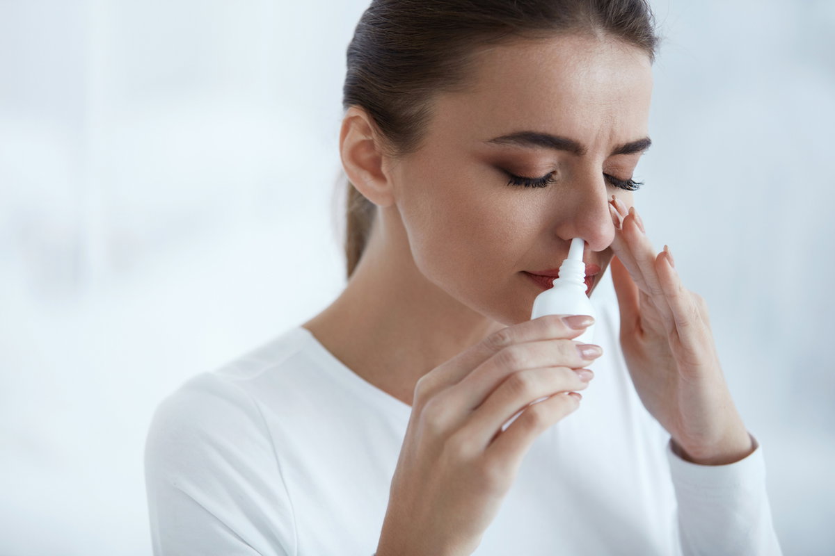 Frau nutzt Nasenspray