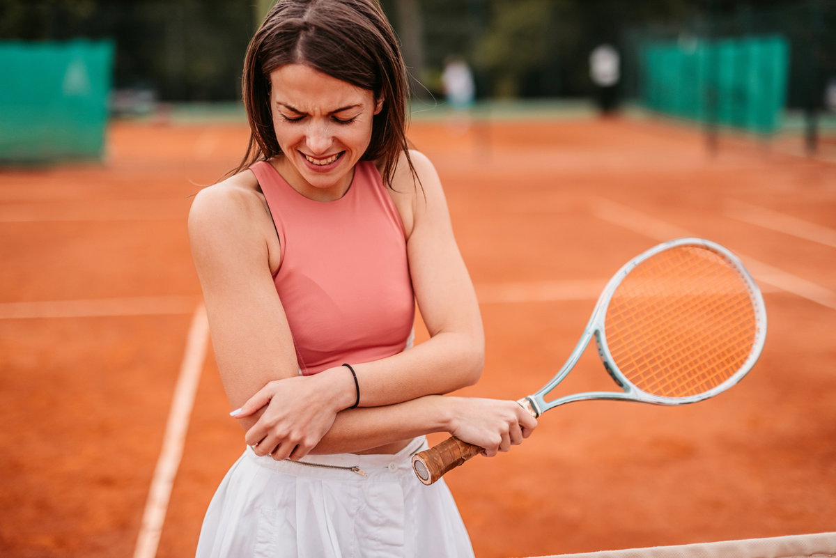 Tennisspielerin hält sich Arm
