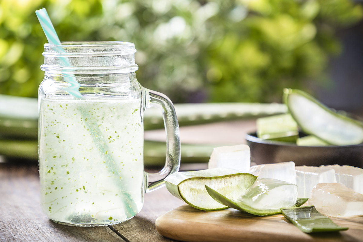frischer Aloe Vera Saft in Glas mit Strohhalm