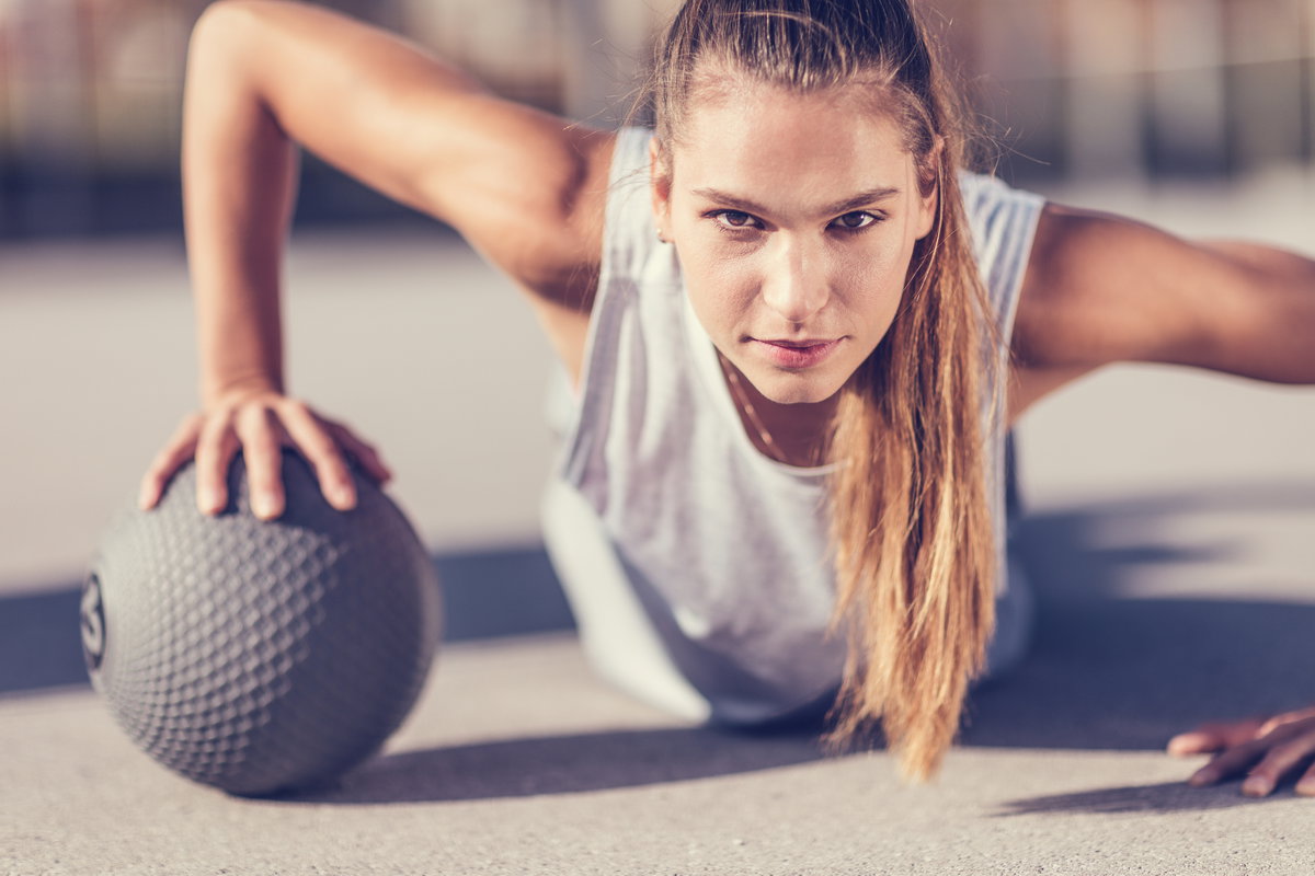 Frau macht Liegestütz mit Ball
