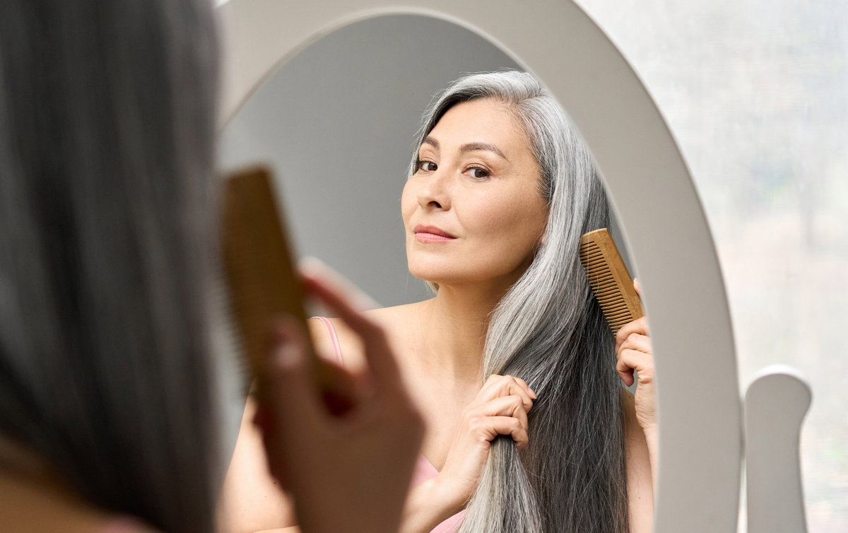 Frau kämmt graue Haare