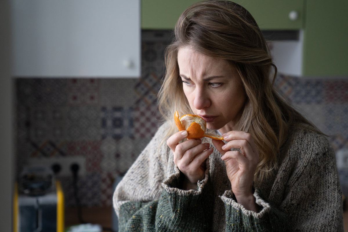 Frau riecht an Orange