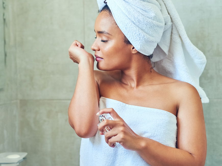 Frau riecht an Parfum nach Dusche