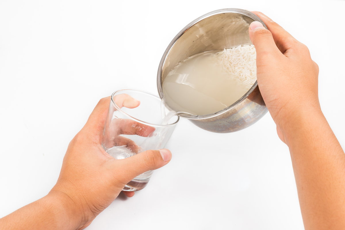 Reiswasser wird in Glas gefüllt