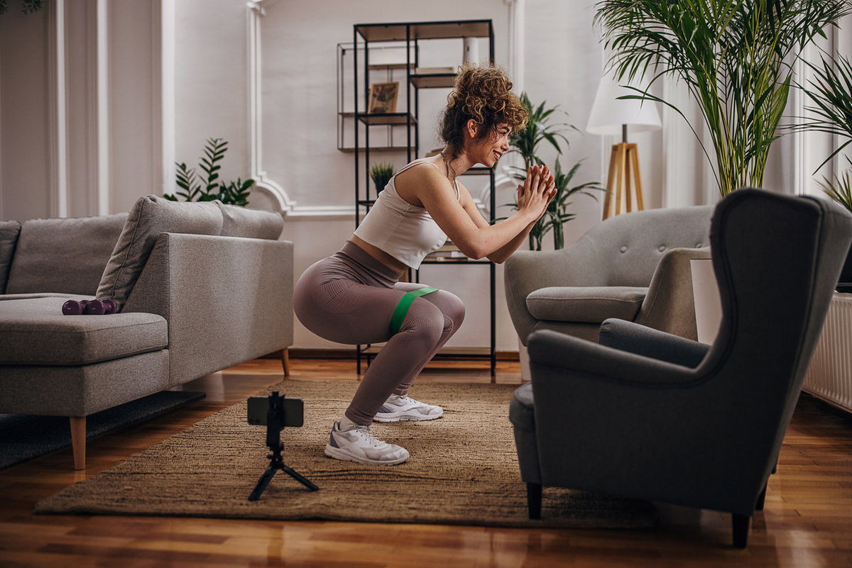 Frau macht Squats in der Wohnung