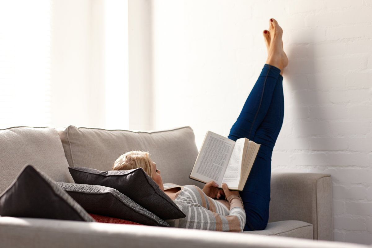 Frau liegt auf Sofa