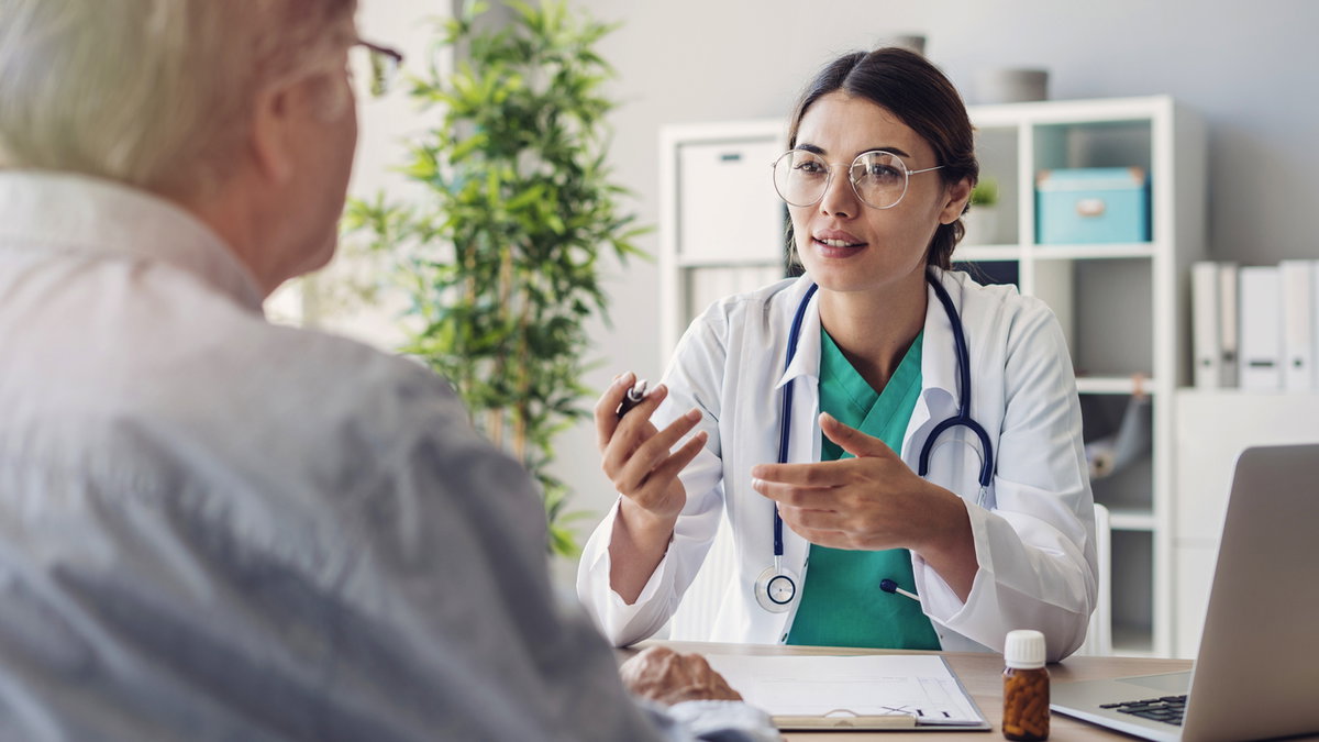 Ärztin im Patientengespräch mit älterem Mann