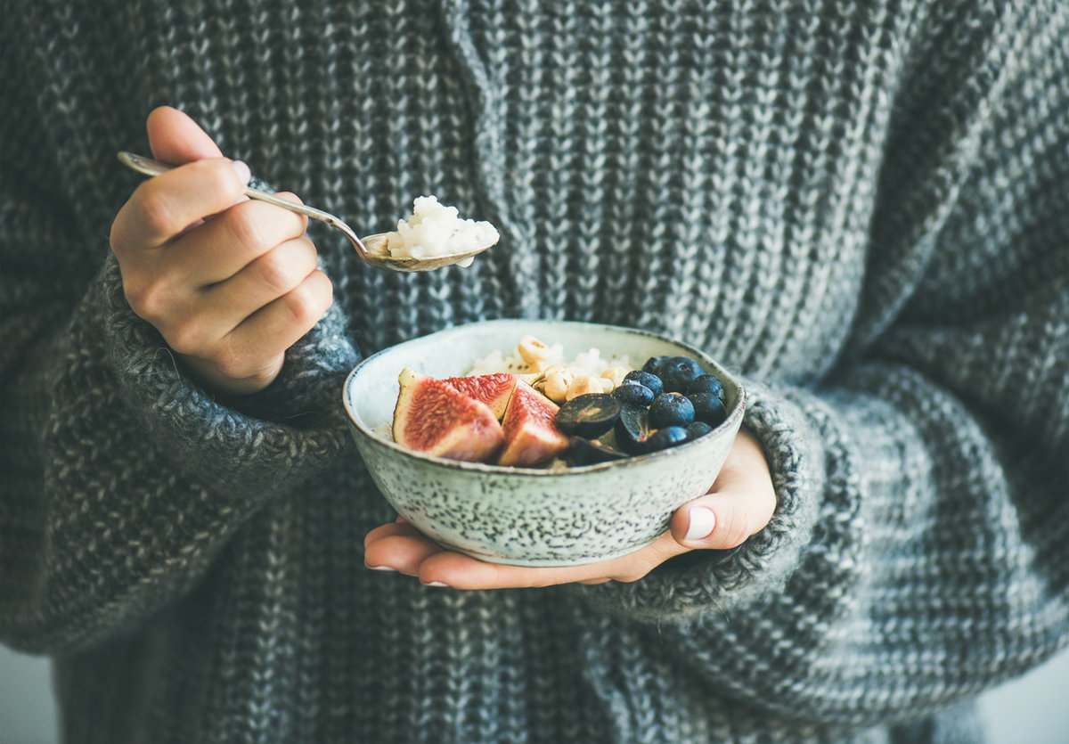 Frau isst Porridge im WInter