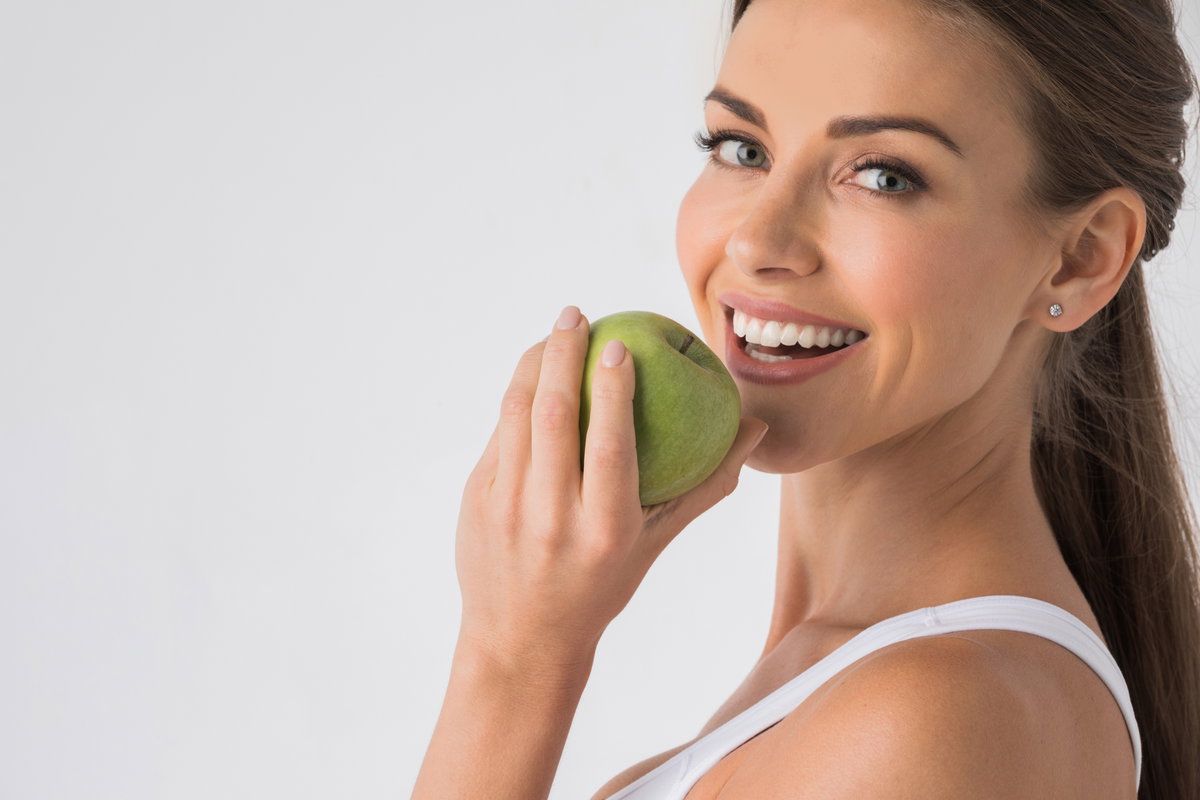 Lachende Frau mit Apfel