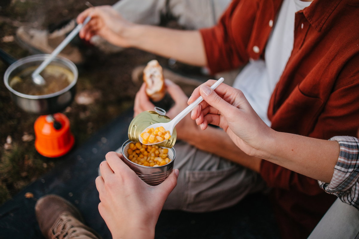 Menschen essen beim Campen aus der Dose