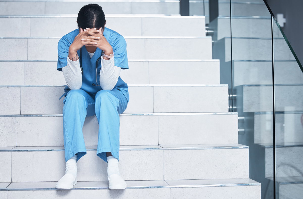 Ausgebrannte Ärztin sitzt auf Krankenhausstufen