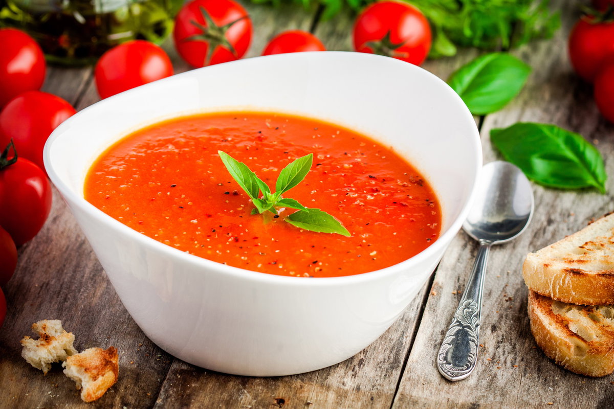 Tomatensuppe in Schüssel auf Holztisch