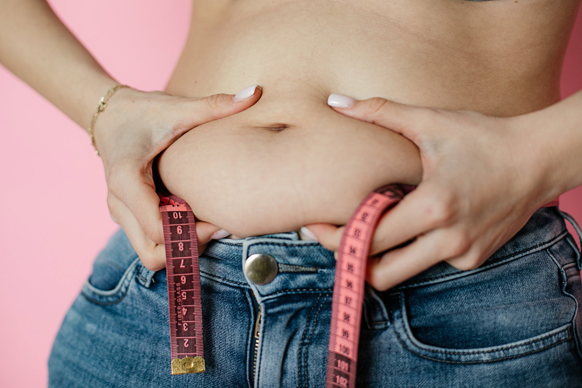 Frau greift Bauch mit beiden Händen