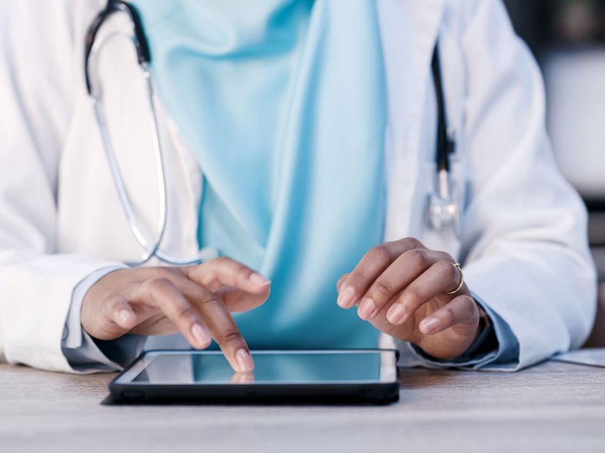 Ärztin nutzt Tablet zur Patientendatenübertragung