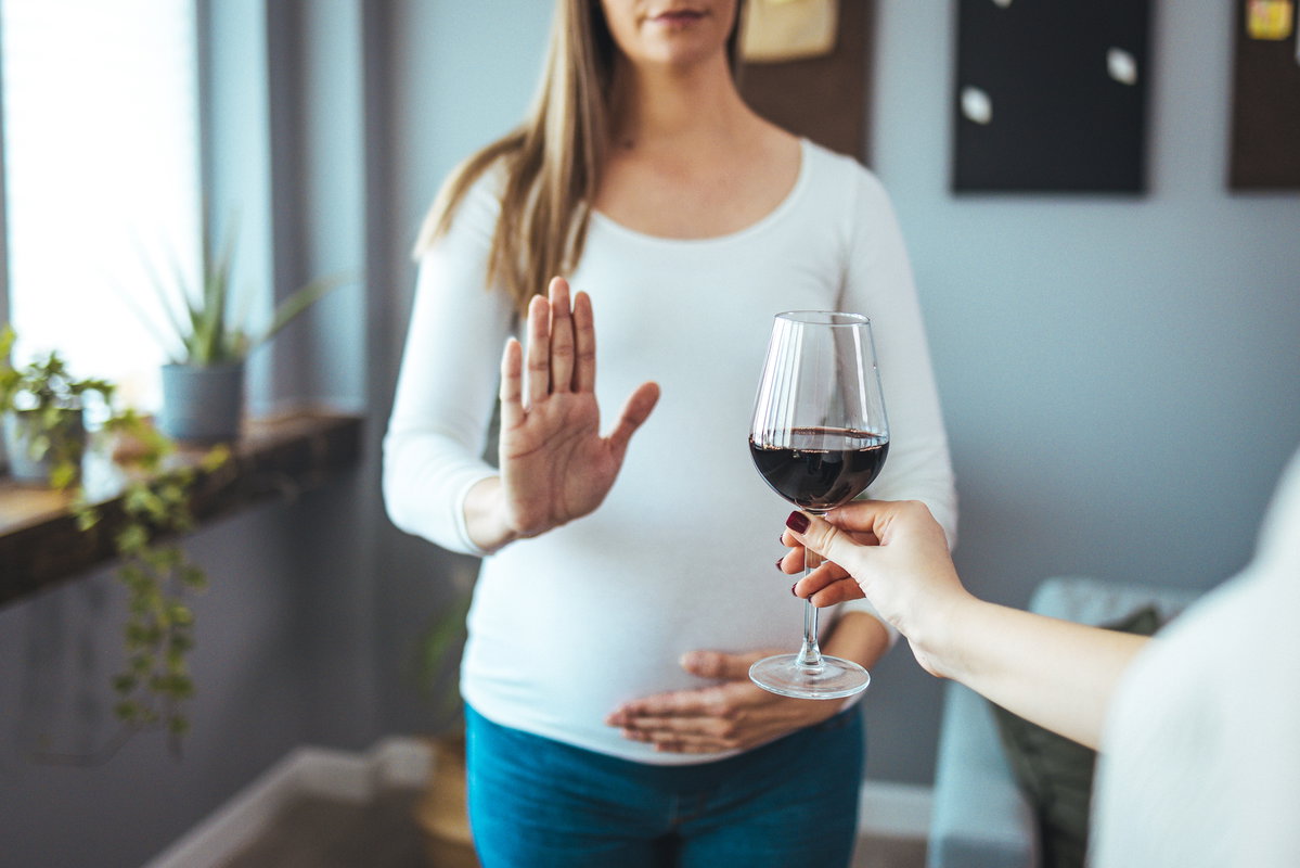Frau lehnt Glas Rotwein ab