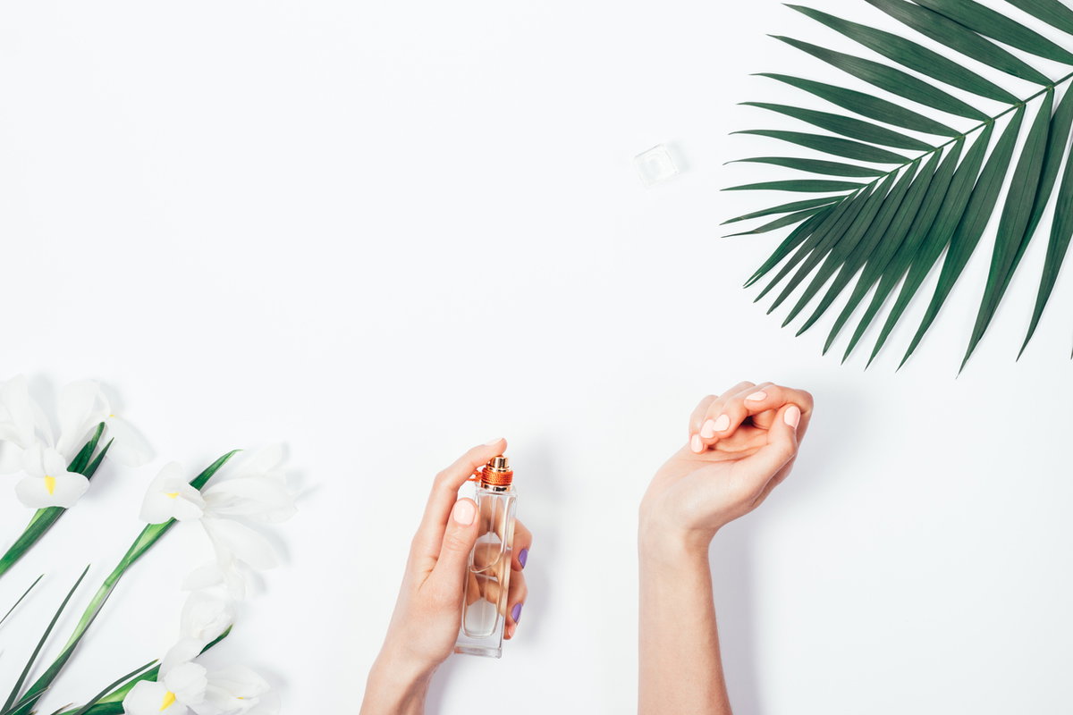 Frau sprüht Parfum auf das Handgelenk
