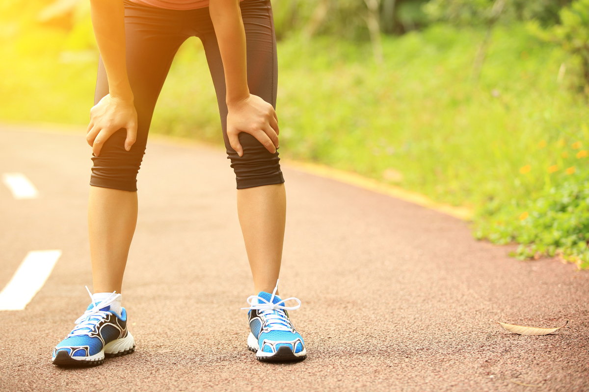 Joggerin stützt sich auf Knien ab
