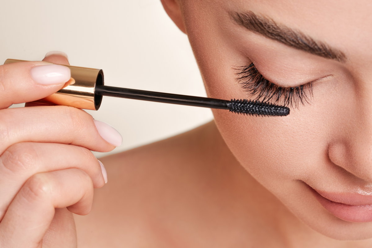 Frau tuscht Wimpern