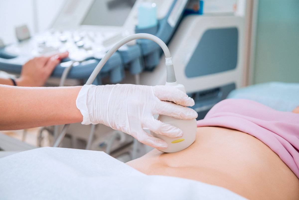 Ärztin untersucht Bauch einer Patientin mit Ultraschall