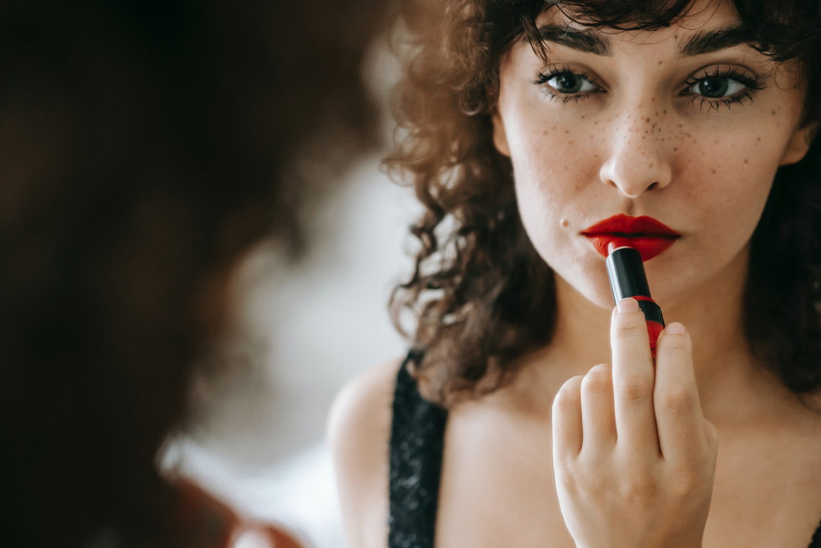 Frau trägt Lippenstift auf